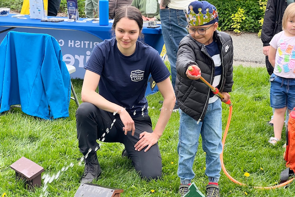 Gurikk Sihu knocks down some fire at the FireSmart booth on May 25, 2025 with Williams Lake Wildfire Risk Reduction and FireSmart Coordinator Taya Vanderkop-Girard
