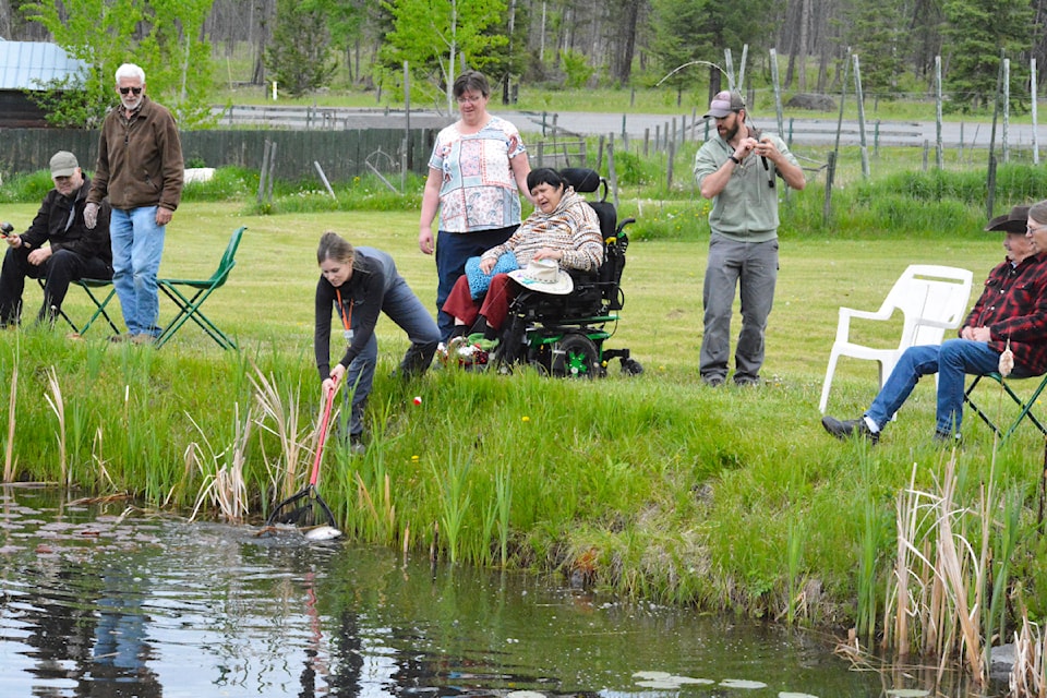 It's all hands on deck as a fish is reeled in at Biff's Ponds. 