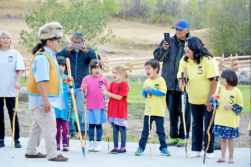 Esket cultural and language teacher Floyd Dick (left) leads students and teachers in song during a celebration of the community’s new Ssoxomic School held Monday. Monica Lamb-Yorski photo