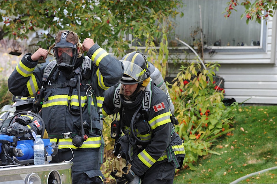 Firefighters prepare to enter a home on Yorston Street Friday damaged by fire. Angie Mindus photos