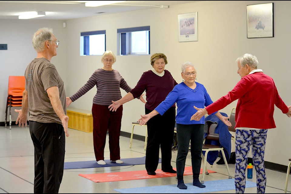 Yoga instructor Paul Couturier (left) leads Joanne Laird, Pauline MacBurney, Pat Cassidy, and Floris Martineau in a sun salutation at the Seniors Activity Centre on Friday.