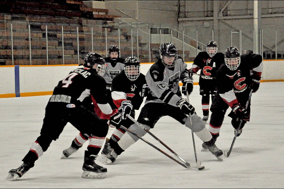 Williams Lake Bantam Timberwolves forward Max Sanford carries the puck through an onslaught of Prince George defenders in Sunday’s third and deciding Cariboo Amateur Hockey Association playoff final — a 5-2 win for the Cougars. (Greg Sabatino photos)