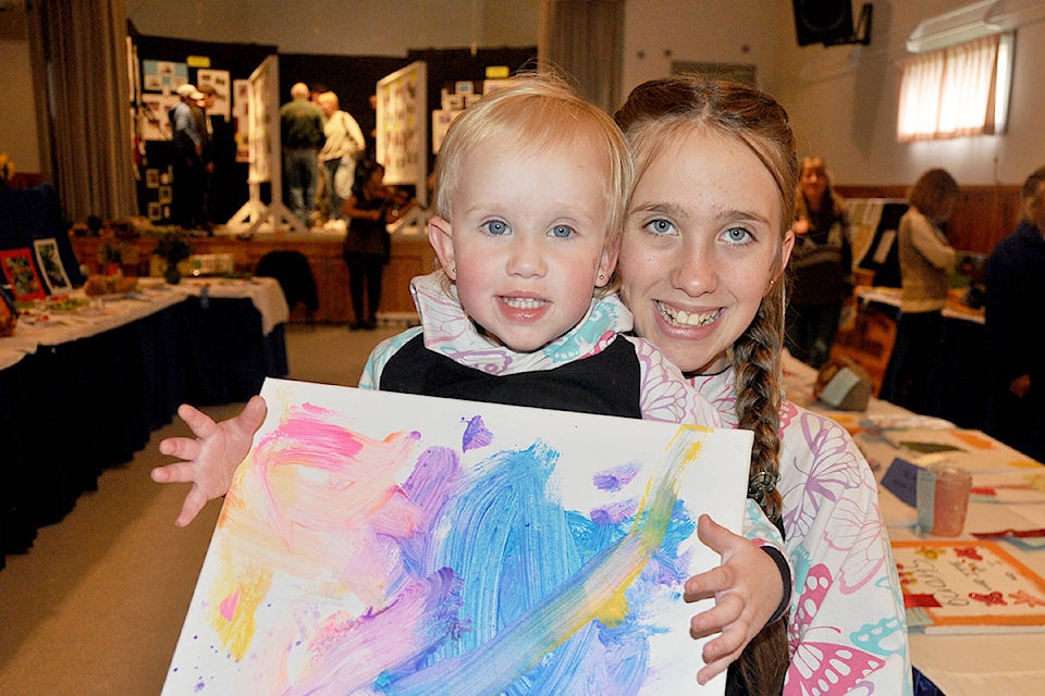 Lyra Schaafsma two years old, pictured here with her sister, Lacy, made a finger painting to enter in the Horsefly Fall Fair. Both girls contributed to the children’s art section of the event.