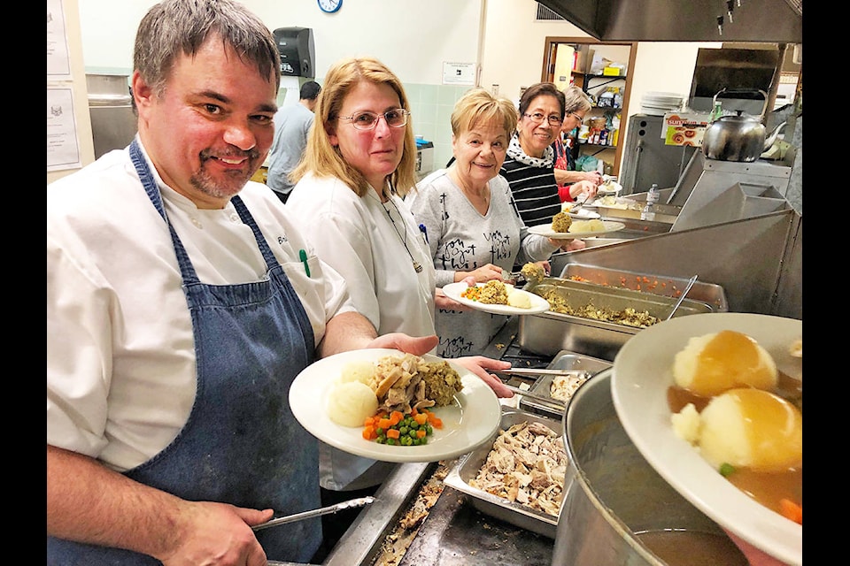 Yuletide dinner volunteers head chef Brice O’Neill (from left), sous-chef Kathy Turner, Paulette Hrynkewich, Beth Neville and Jane Straub dish up the plates in a very orderly fashion at the annual community dinner Wednesday evening. The event provided a beautiful, delicious Christmas meal to those in need this year. Angie Mindus photos