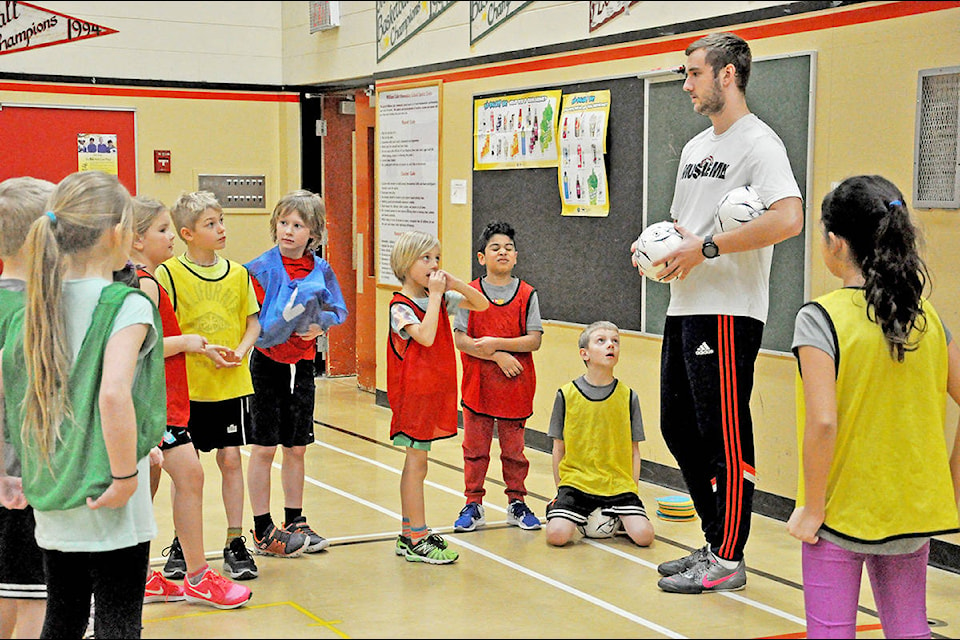 Williams Lake Youth Soccer Association U8-U12 coach Oliver Hitch gives some instruction to players Georgia Holm (from left), Brooklynn Hoppner, Ty Thiessen, Emerson Doering, Aiden Fischer, Abdullah Marhoon, Reece Firth, coach Hitch, Michellaine Evans during a practice last week at Nesika elementary. (Greg Sabatino photo)