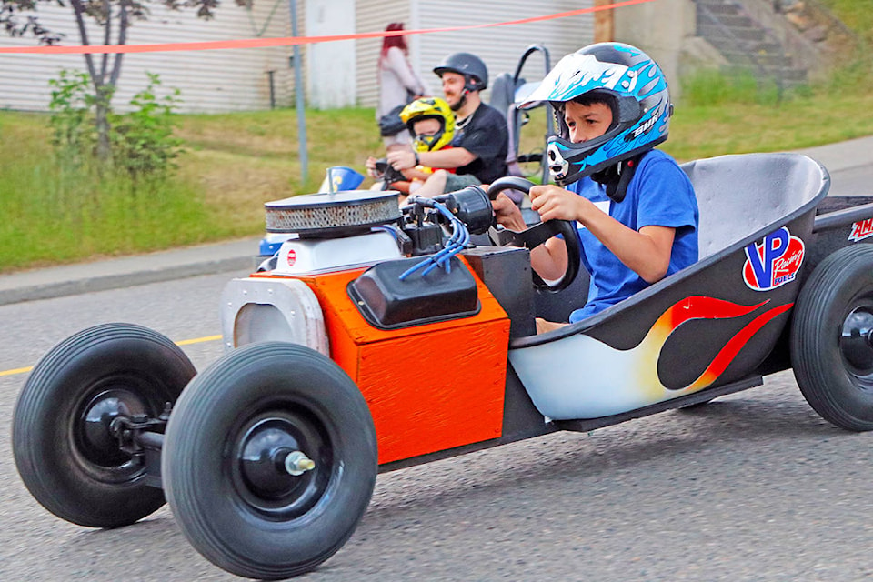 Kenny Campbell (front) races ahead of Darian and Allen Kariechuk (back) during the Soapbox Derby held at Cariboo GM Thursday evening. Campbell picked up so much speed that he blew right through the haybales at the base of the hill. Patrick Davies photo.