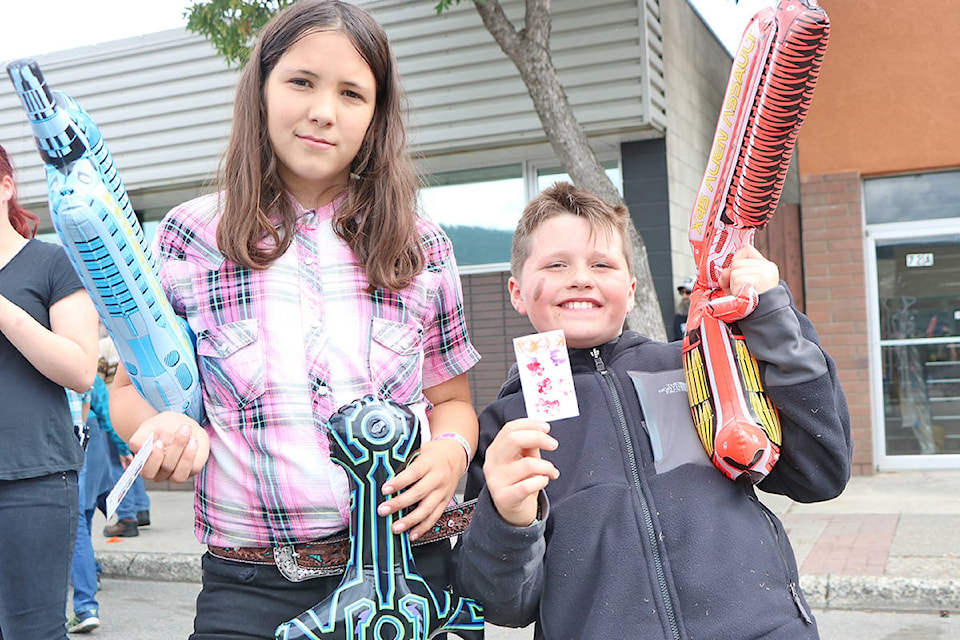Sarina Harris along with her friend Liam Reid shows off their spoils earned from playing mini carnival games at the Stampede Street Party’s Kid Zone. Patrick Davies photo.