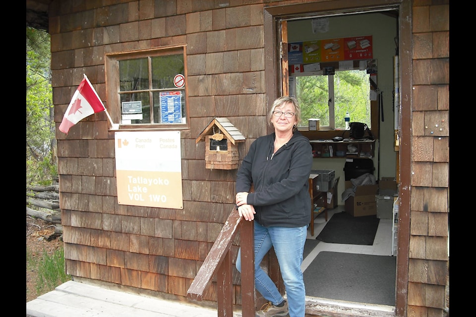 Postmaster Joanna Knight stands in front of the Tatalayoko Post Office- the second smallest post office in B.C., however, an integral part of the community. Sage Birchwater photo.