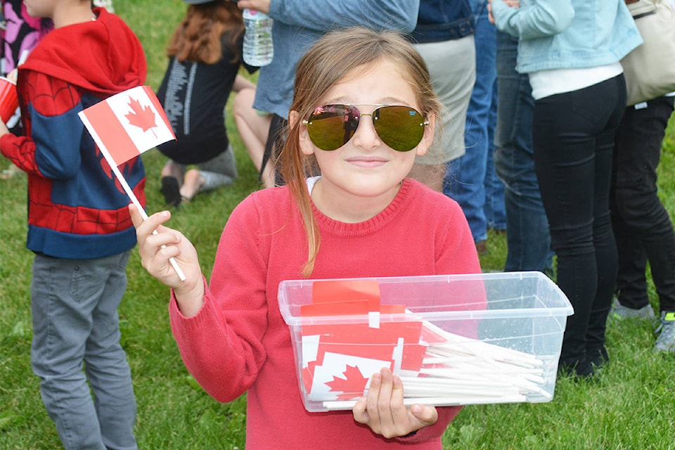Monica Lamb-Yorski photos Sienna Kalashnikoff, 7, hands out flags during the Canada Day celebration in Boitanio Park.