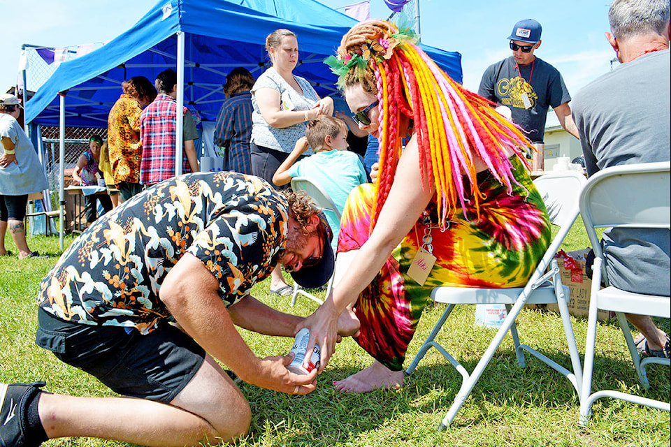 Visual artist David Jacob Harder (left) and his borther Aaron (standing) led a casting workshop during Arts on the Fly Saturday afternoon. Here David creates a foot form with Niki Cockwill of Williams Lake who was the volunteer vendor co-ordinator for the festival. Monica Lamb-Yorski photo