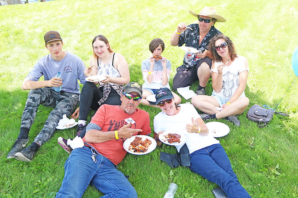 Family friends who are “more like family” Stefan Licko (back from left), Arien MacDonald, Kimberly Poirier, Donald MacDonald, Renee MacDonald enjoy some ribs along with Pierre Poirier and Mercedes Poirier enjoy some ribs at the Williams Lake Rib Festival in Boitanio Park. Patrick Davies photo.