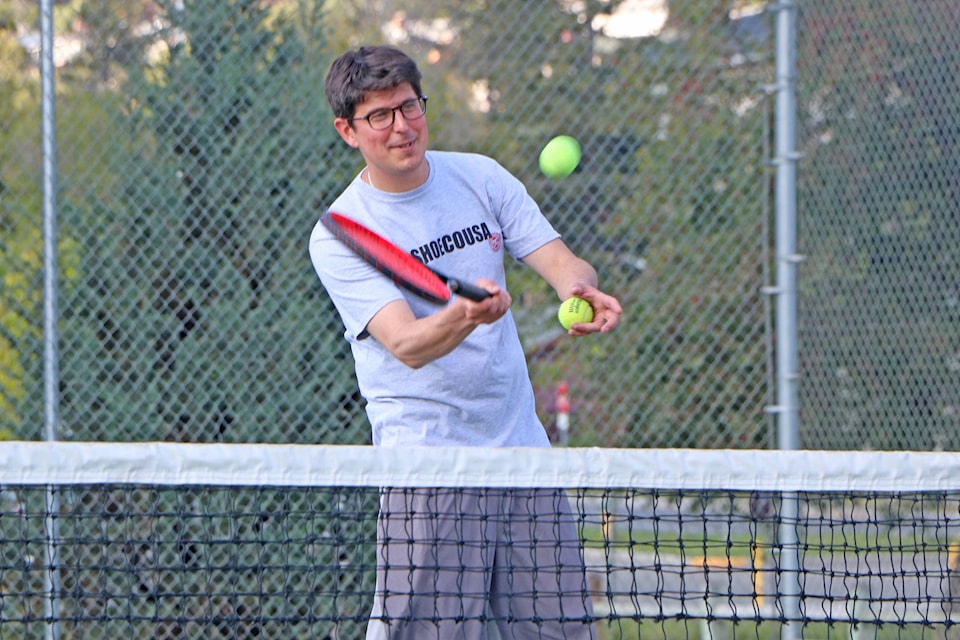 Greg Sabatino smiles as he serves a ball for one of the aspiring tennis players he taught last week. Patrick Davies photo.