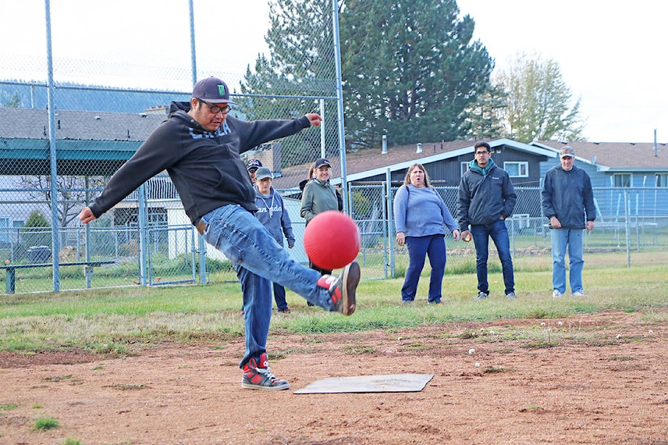 Onlookers begin to cheer as Eddie William kicks the opening pitch during a game of kickball held to mark Community Living Month in Williams Lake on Wednesday, Oct. 16. Patrick Davies photo.
