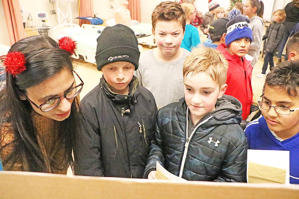 Arwinder Kaur (from left) instructs Ben Zirnhelt, Asher Hollet, Caelum Llewellyn, Simar Singh, Roman Aulakh on the topic of how to stay healthy and vaccinate at the Wellness Clinic hosted on Friday, Dec. 6. (Patrick Davies photo- Williams lake Tribune)