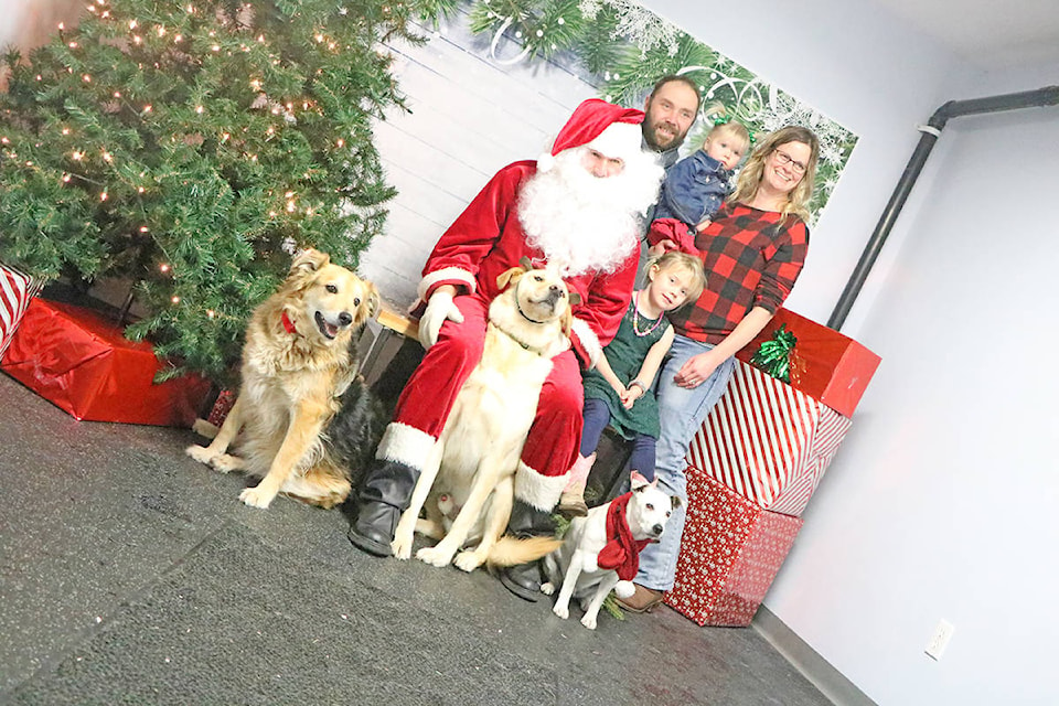 Dogs Kali (from left) Jack and Diesel for a photo with their family the Iversons Keith (from left), Paige, Ella and Michelle along with Santa Claus. The Iverson family has been attending Pet Photos with Santa for the last eight years ever since they used it to announce the birth of their daughter, Ella. (Patrick Davies-Williams Lake Tribune).