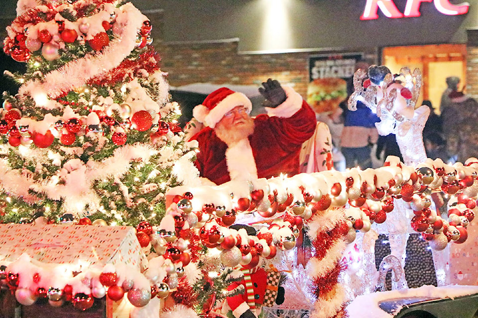 Santa Claus waves cheerfully from the back of a float in the annual Winter Lights Parade. (Patrick Davies-Williams Lake Tribune)