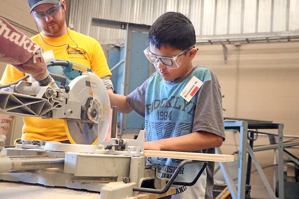 Thompson Rivers University was filled with Grade 7 Students from Columneetza on Wednesday, Feb. 19 who were attending the annual Youth Discover the Trades, an event whose goal is to introduce the youth of the lakecity to the possibilities of a career in the trades. Welders, millwrighters, mechanics, electricians and carpenters all go the chance to share their skills with young teenagers, including Kyle Batty seen here directing young Breandan Wycotte on how to use a circular saw. (Patrick Davies photo - Williams Lake Tribune)