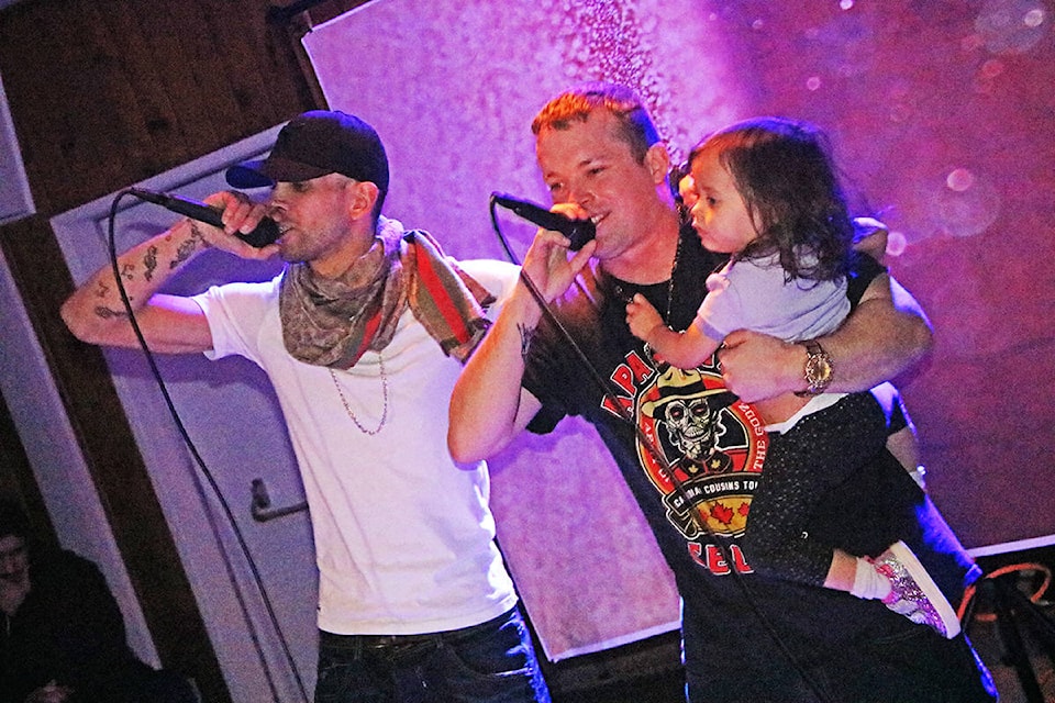Jordan Salazar aka Sal the Sinner (from left) raps alongside Bryan ‘Bioson’ Delaronde as he holds his daughter Marcy Delaronde in his arms, something he said he’d thought he’d never do. (Patrick Davies photo - Williams Lake Tribune)