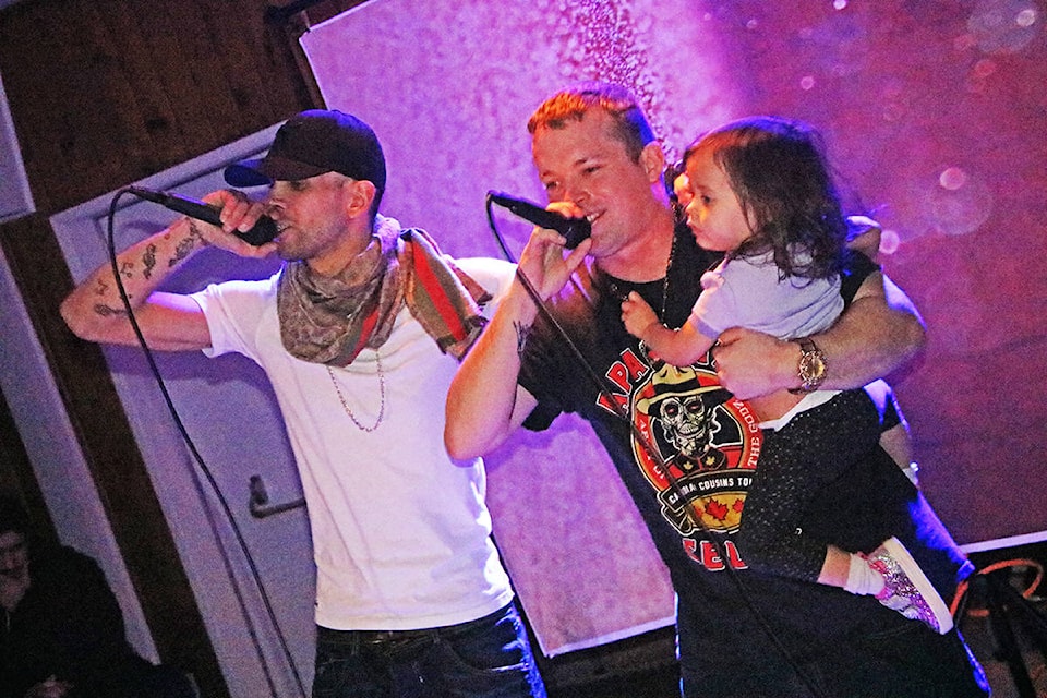 Jordan Salazar aka Sal the Sinner (from left) raps alongside Bryan ‘Bioson’ Delaronde as he holds his daughter Marcy Delaronde in his arms, something he said he’d thought he’d never do. (Patrick Davies photo - Efteen)