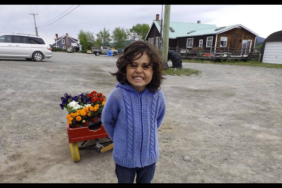 Kindergarten student Tony Daud was on hand and cheerfully loading up the red wagon and pulling it to the waiting cars, announcing the delivery had arrived. Tony would happily hop in to be pulled back to the horse trailer for the next load. (Linda Lou Howarth photo)