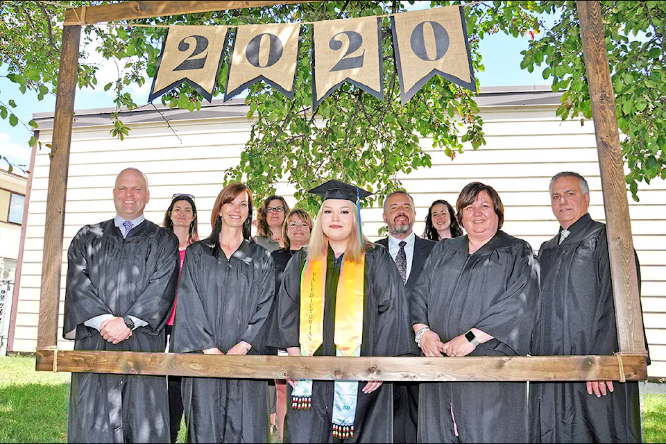 Skyline valedictorian Layla Wycotte (front, centre) stands in the photo booth alongside school staff Bev Dawes (back from left), Heather Auger, Saibra Larden, Gord Weber, Shelley Cameron, principal Curt Levens (front from left), Dena Gysel, Patti Stolar and Peter Bowman Wednesday during the school’s graduation ceremony. (Greg Sabatino photo - Efteen)