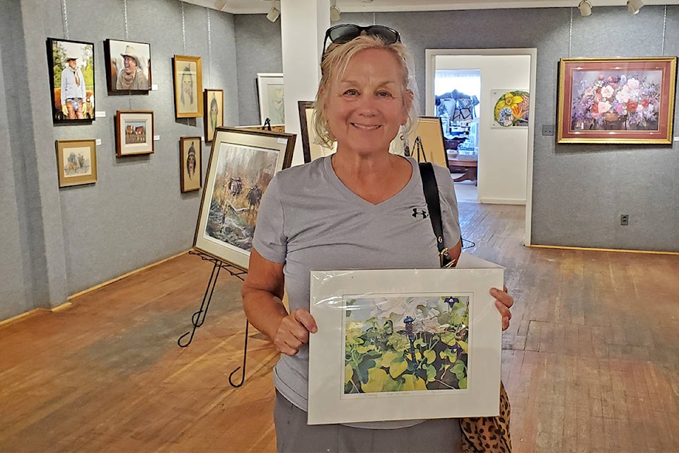 Helen Kormendy of Ashcroft purchased a limited edition print from the Station House Gallery Middleman show in Williams Lake when she stopped in en route for work. The show officially runs from Sept. 12 to 26. (Monica Lamb-Yorski photo - Williams Lake Tribune)
