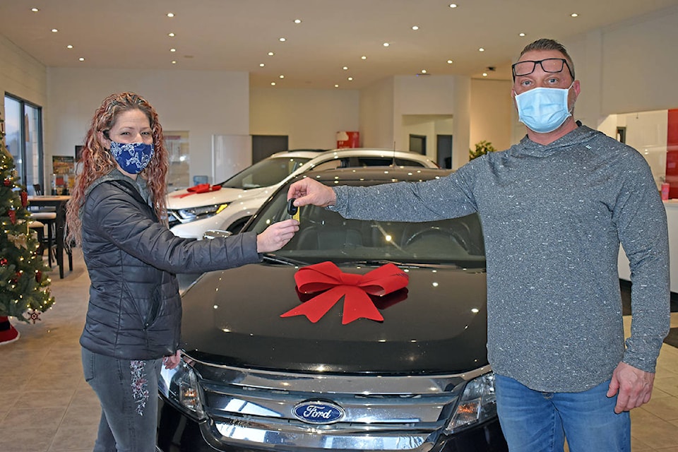 Cory Herle (right) of Ranchland Honda hands the keys to a loaded 2010 Ford Fusion SEL to Lisa Anderson. (Rebecca Dyok photo)