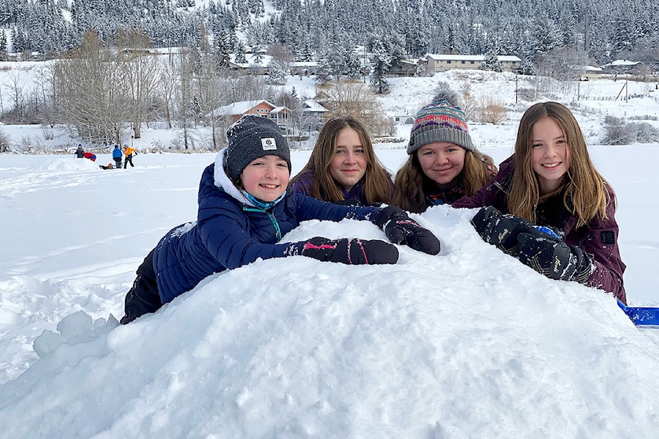 Camdyn Cochran (from left), Raelee Slavens, Cassidy Huffman and Anna Fait of the Grade 7 outdoor education class learn how to build a snow shelter, or quinzee, during class on the lake Wednesday, Feb 17, 2021. (Angie Mindus photo - Williams Lake Tribune)