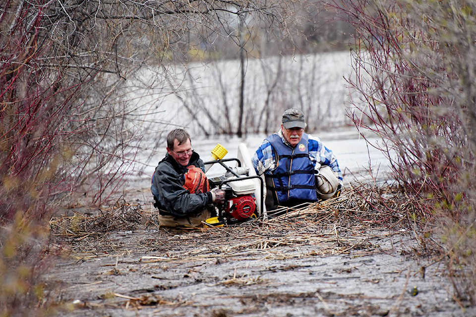 Williams Lake Field Naturalists volunteers Ken Day and Don Lawrence pack equipment in waist-deep water on the main trail at Scout Island during the 2020 floods. The photo has received a nomination by the BCYCNA for spot news photo award. (Angie Mindus photo/Williams Lake Tribune)