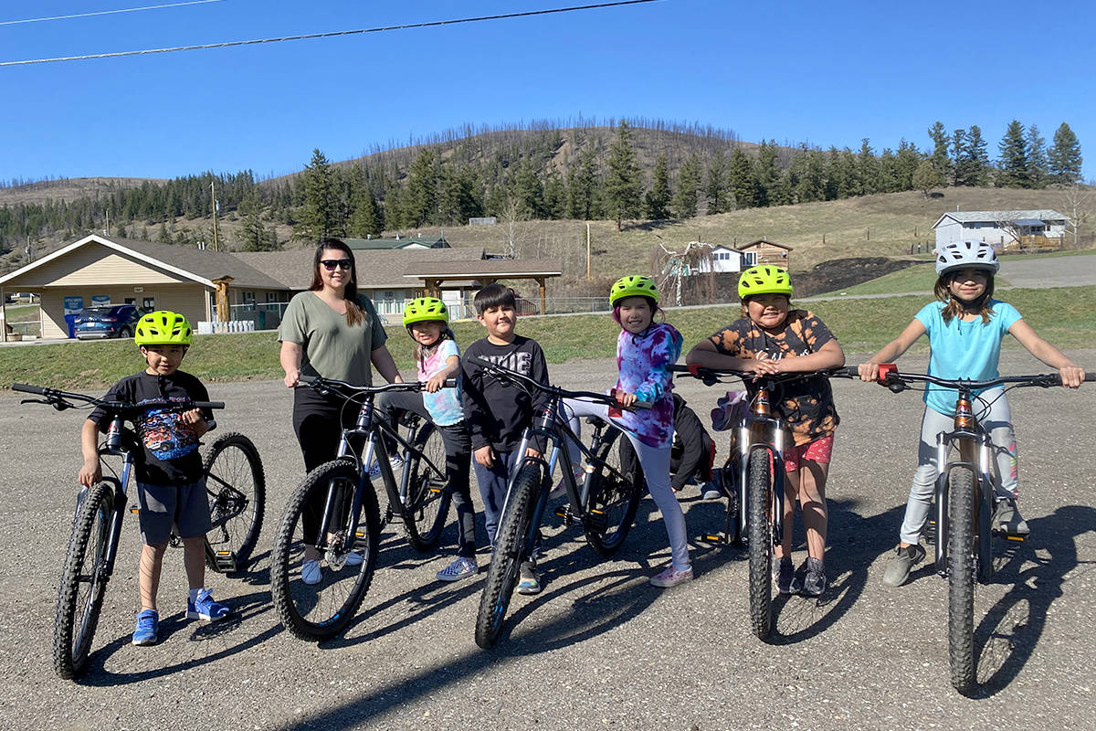 Sugar Cane youth, along with WLFN councillor Shawna Philbrick, are all smiles as they take some new mountain bikes for a test ride Monday afternoon. (Angie Mindus photo - Efteen)