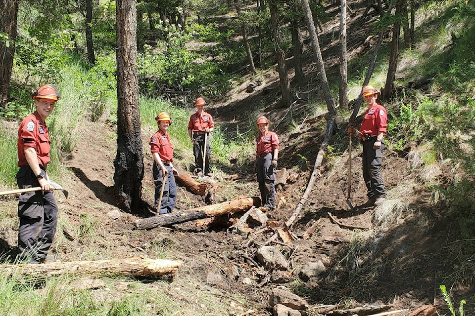 Cariboo Fire Centre Vesta crew members finish extinguishing a fire in the woods above the 1200 block of Lakeview Crescent near the power line Thursday morning. (Monica Lamb-Yorski photo - Williams Lake Tribune)