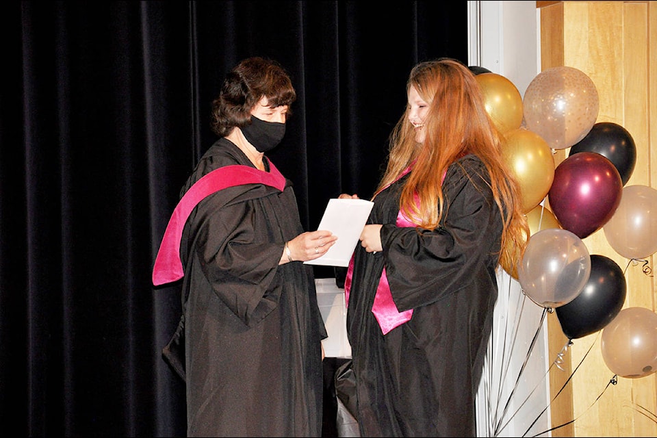 Graduate Belle Riding is congratulated by Lake City Secondary School learning support teacher Gail Gardner as she makes her way across the stage to receive her diploma. (Greg Sabatino photo - Williams Lake Tribune)