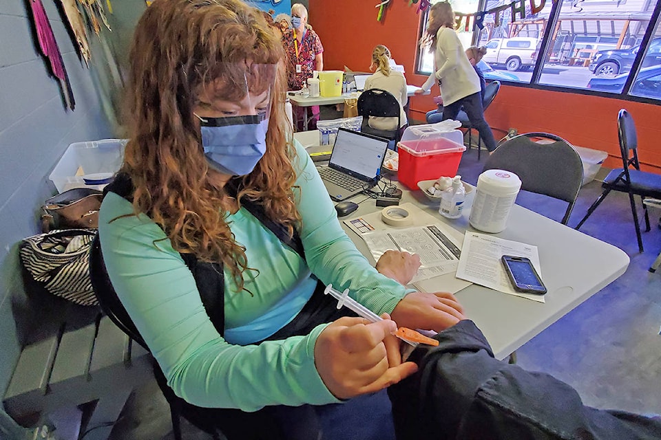 Kelsey Hollet administers the COVID-19 vaccine during a pop-up clinic held at Paradise Cinemas on Saturday, Aug. 21. (Monica Lamb-Yorski photo - Williams Lake Tribune)