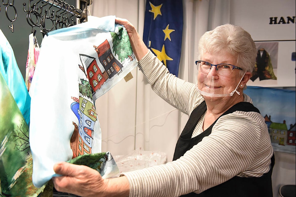 “The Mushroom Lady” Carolyn Thomspon shows off some of her handpainted silk scarves at her vendor booth at the Medieval Market on Saturday, Nov. 20. (Ruth Lloyd Photo - Williams Lake Tribune)