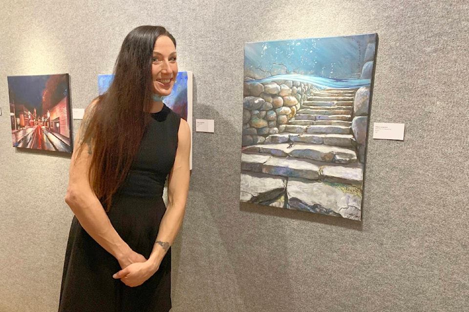 Tiffany Jorgensen, one of the artists from Cariboo Art Beat, featured in the Station House Gallery show on now, Better Together, poses next to her favourite work in the show, What the F is Happening . (Ruth Lloyd photo - Efteen)