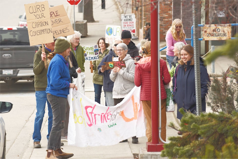 Third Planet Crusade leaders and participants stopped in front of the entrance to RBC in downtown Williams Lake to draw attention to RBC’s role in financing the fossil fuel industry. (Ruth Lloyd photo - Williams Lake Tribune)