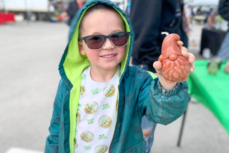 Kiro Lewis proudly displays the gnome beeswax candle he chose from Bee-spelled Candles at the Williams Lake Farmers Market on May 13, 2022. (Ruth Lloyd photo - Williams Lake Tribune)