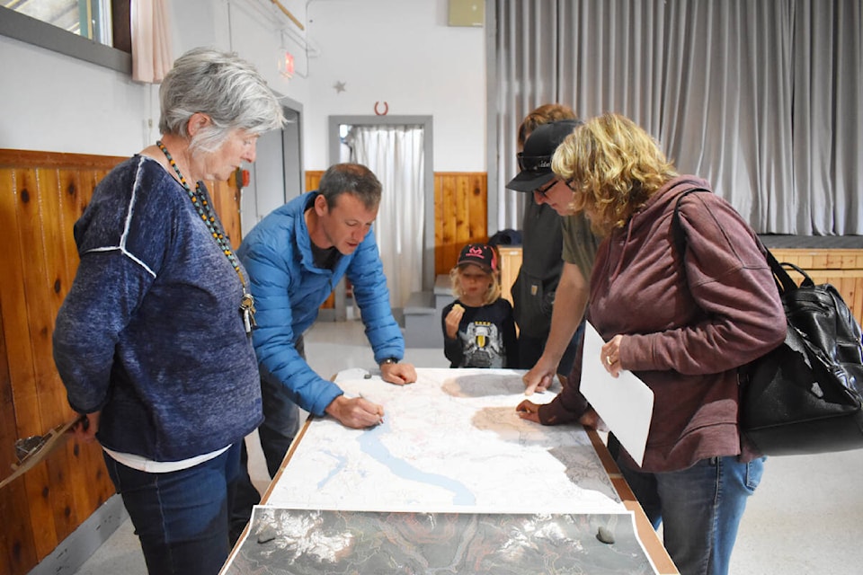 Tolko Industries Ltd. forester Rob Van Burskirk talks about forestry planning around Horsefly Lake with Monika Schlaepfer, left, Kim Harty, Randy and Elaine McLean during an open house at the Horsefly community hall Saturday, May 28. (Monica Lamb-Yorski photo - Williams Lake Tribune)