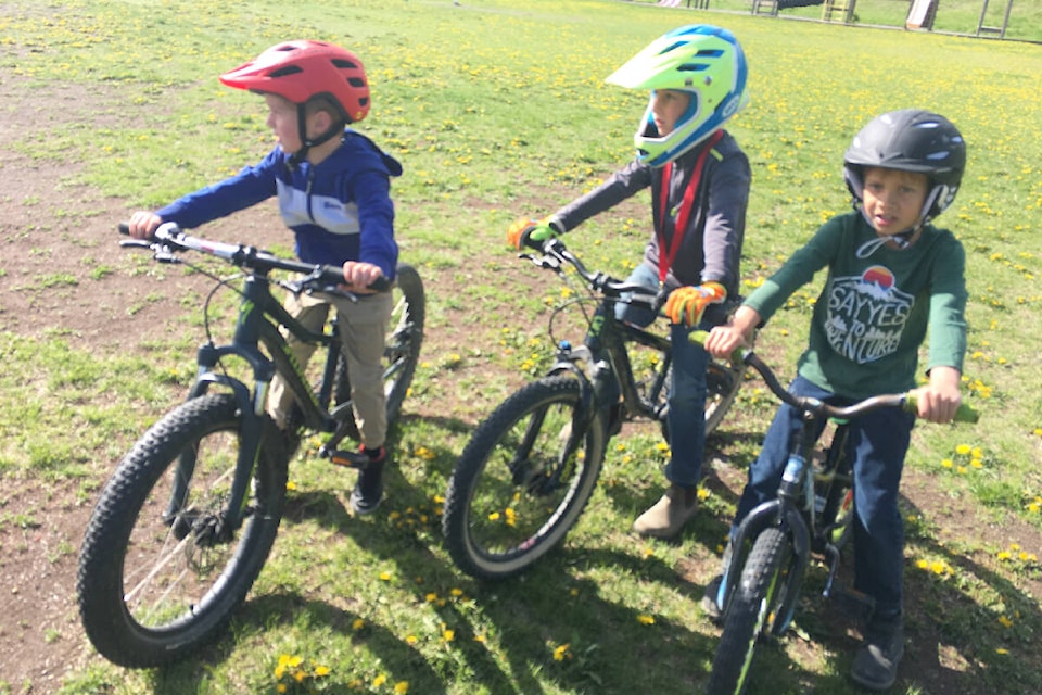 Angus Wellburn, from left, Luke Foote, and Declan Bailey were taking part in the bike rodeo at Chilcotin Road Elementary School on June1 with Red Shred’s Mark Savard and Jacinta D’Andrea. (Jane Wellburn photo)