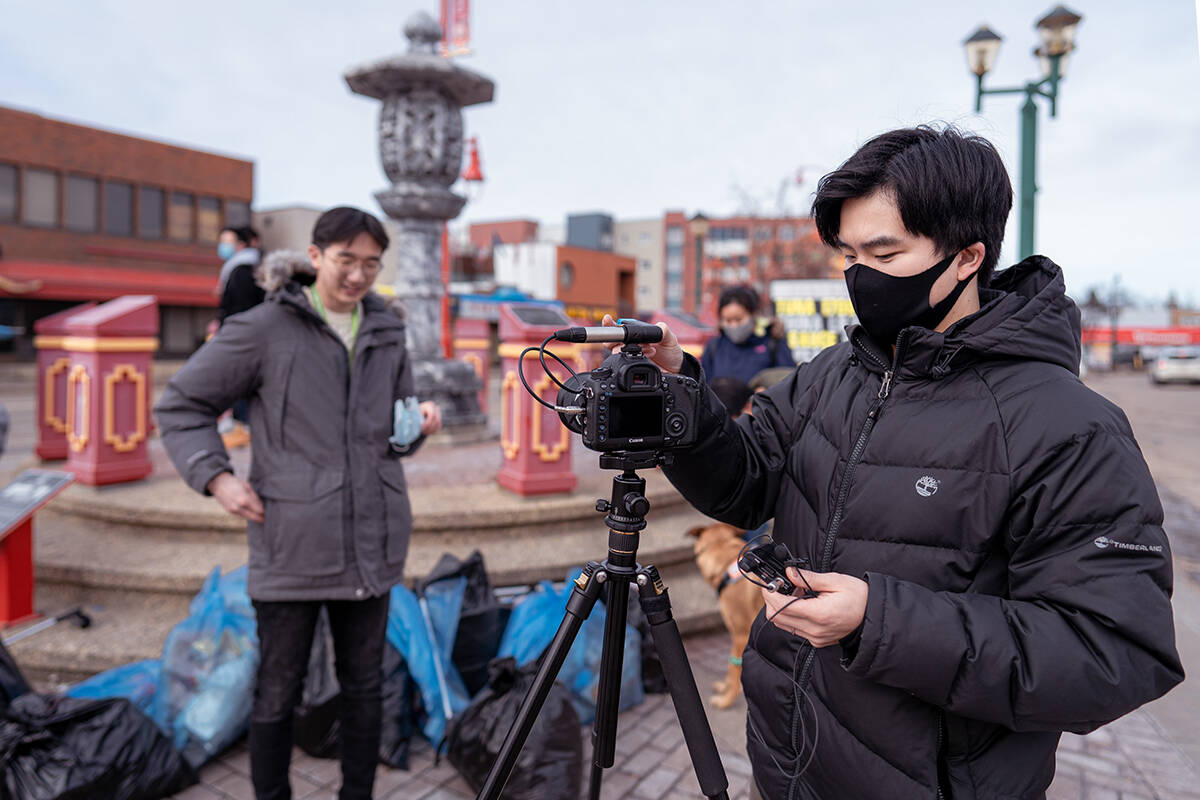 Jordon setting up the camera to interview a Chinatown litter pickup volunteer. Photo by Man Ho.