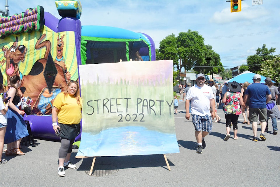 Williams Lake Stampede Street Party Downtown organizer Sunny Dyck stands with one of four signs created by five local youth with Cariboo Art Beat. (Monica Lamb-Yorski photo - Williams Lake Tribune)