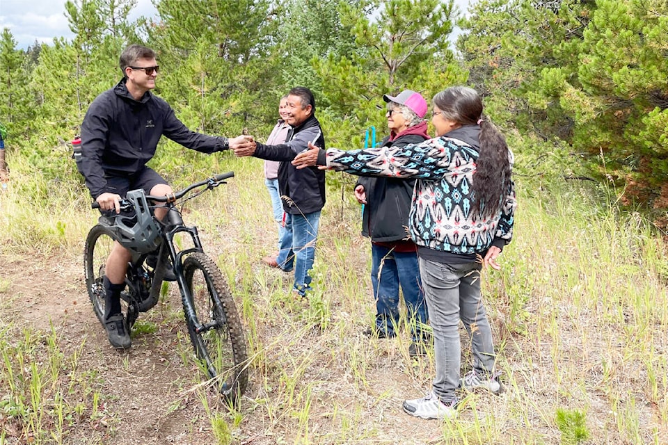 Jonathan Visscher of 100 Mile House high-fives Chief Hank Adam, elder Clara Camille and Dora Demers, who was the economic development officer for SXFN when the trail project began, before heading up Stairway to Heaven. (Ruth Lloyd photo - Black Press Media)