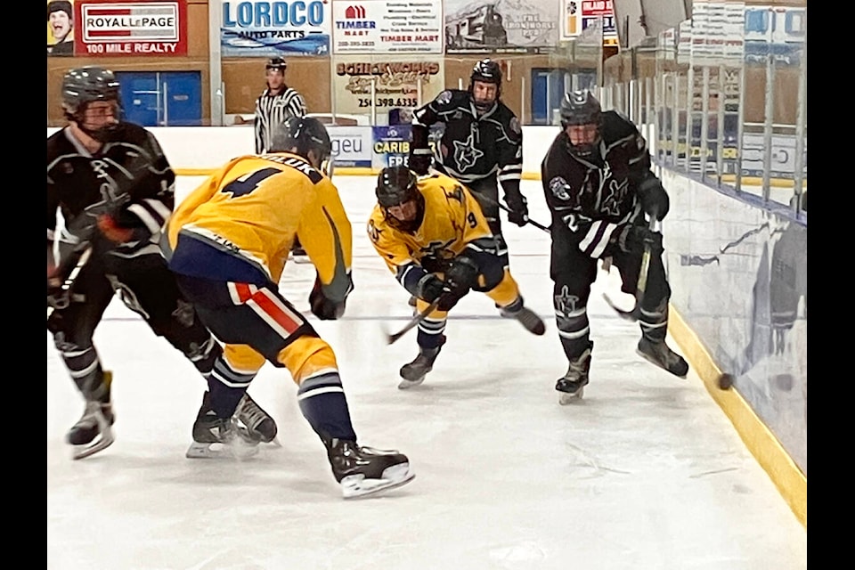 100 Mile House Wranglers Curtis Roorda and Tyler Smoluk maneuver for control of the puck during Sunday’s game with the North Okanagan Knights. (Fiona Grisswell photo - 100 Mile Free Press)
