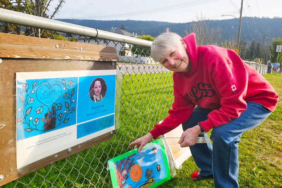 Kathy Newell installs the latest story board in Kiwanis Park in Williams Lake. (Monica Lamb-Yorski photo - Efteen)