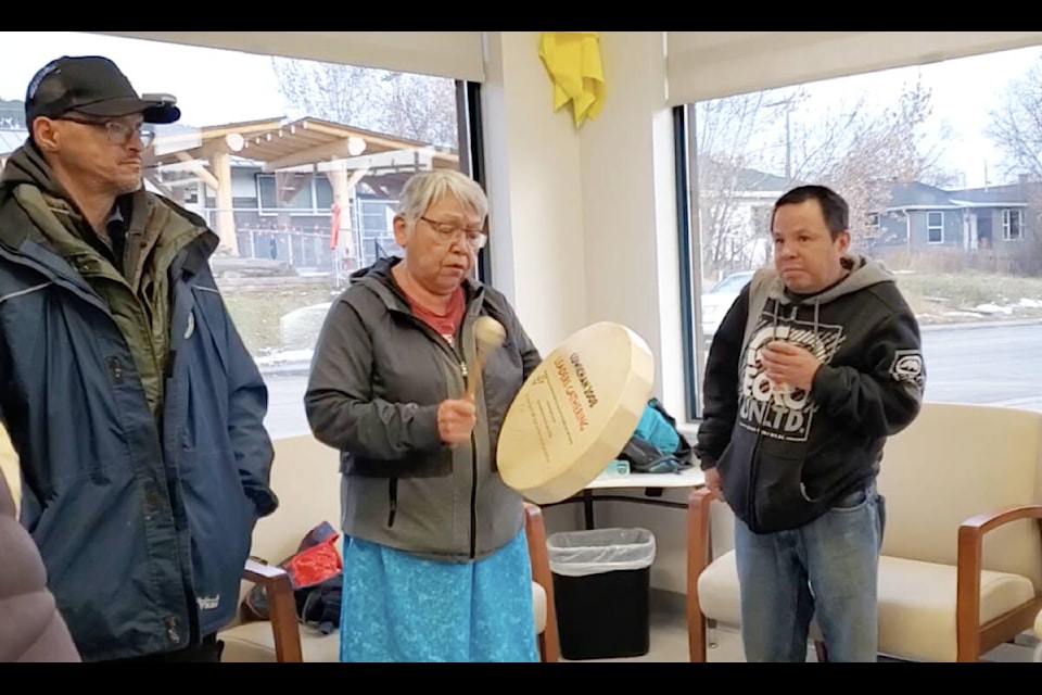 Dean Hare, left, and David Gibbons, right, stand beside Charlene Belleau as she sings at a pop-up education overdose prevention site. (Monica Lamb-Yorski photo - Williams Lake Tribune)