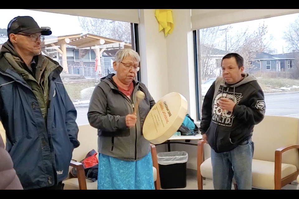 Dean Hare, left, and David Gibbons, right, stand beside Charlene Belleau as she sings at a pop-up education overdose prevention site. (Monica Lamb-Yorski photo - Efteen)