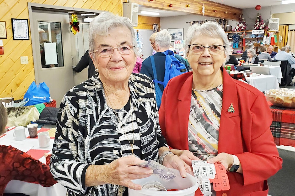 Dot Unrau and Doris Neuert sell 50/50 tickets during the OAPO Christmas Dinner. (Monica Lamb-Yorski photo - Williams Lake Tribune)