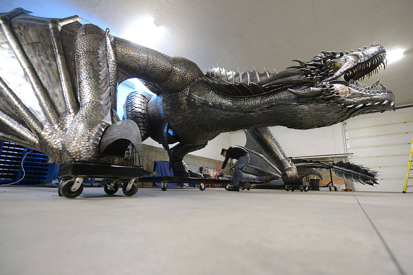 Josh Guretzki wipes off the base of the dragon on Dec. 15, 2022. (Jenna Hauck/ Chilliwack Progress)