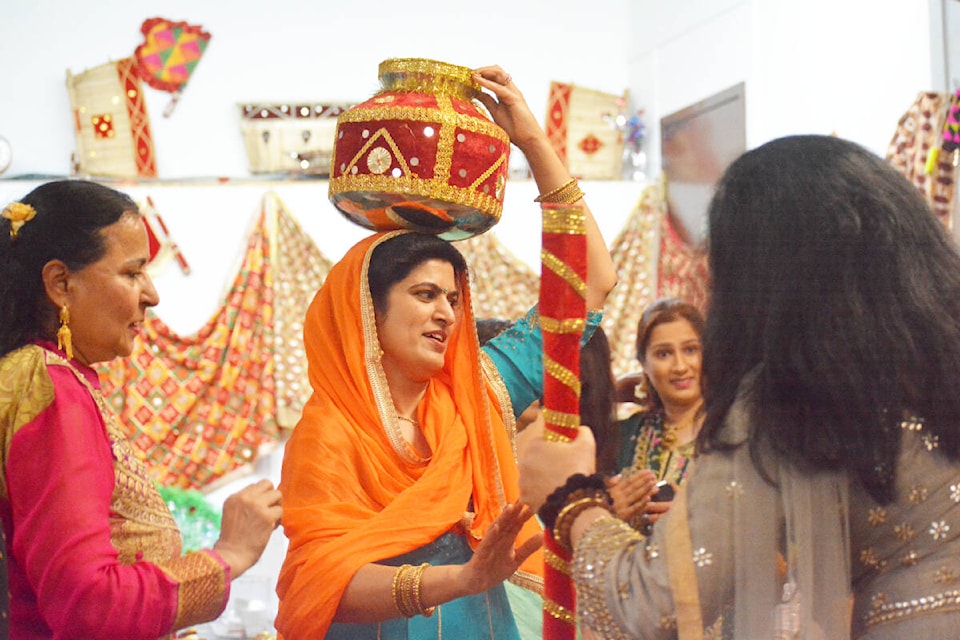 Parmjit Pawar, left, and Ranjit Galsian centre participated in a traditional dance. (Monica Lamb-Yorski photo - Efteen)