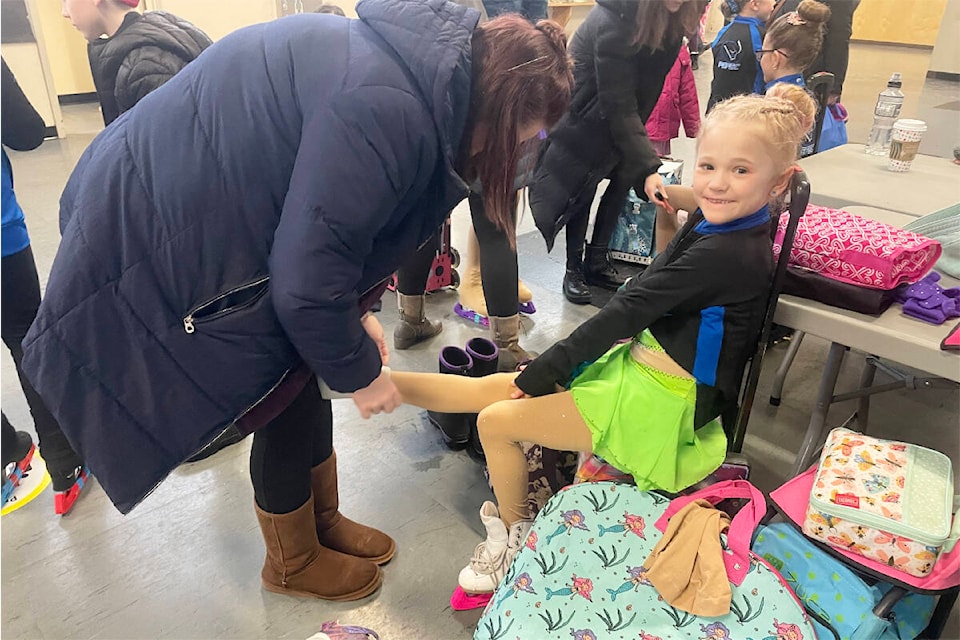 Aria Bond gets some help with her skates as she prepares for competition during the north-central BC and Yukon Skate Canada Regionals in Williams Lake on Jan. 20. (Ruth Lloyd photo - Williams Lake Tribune)